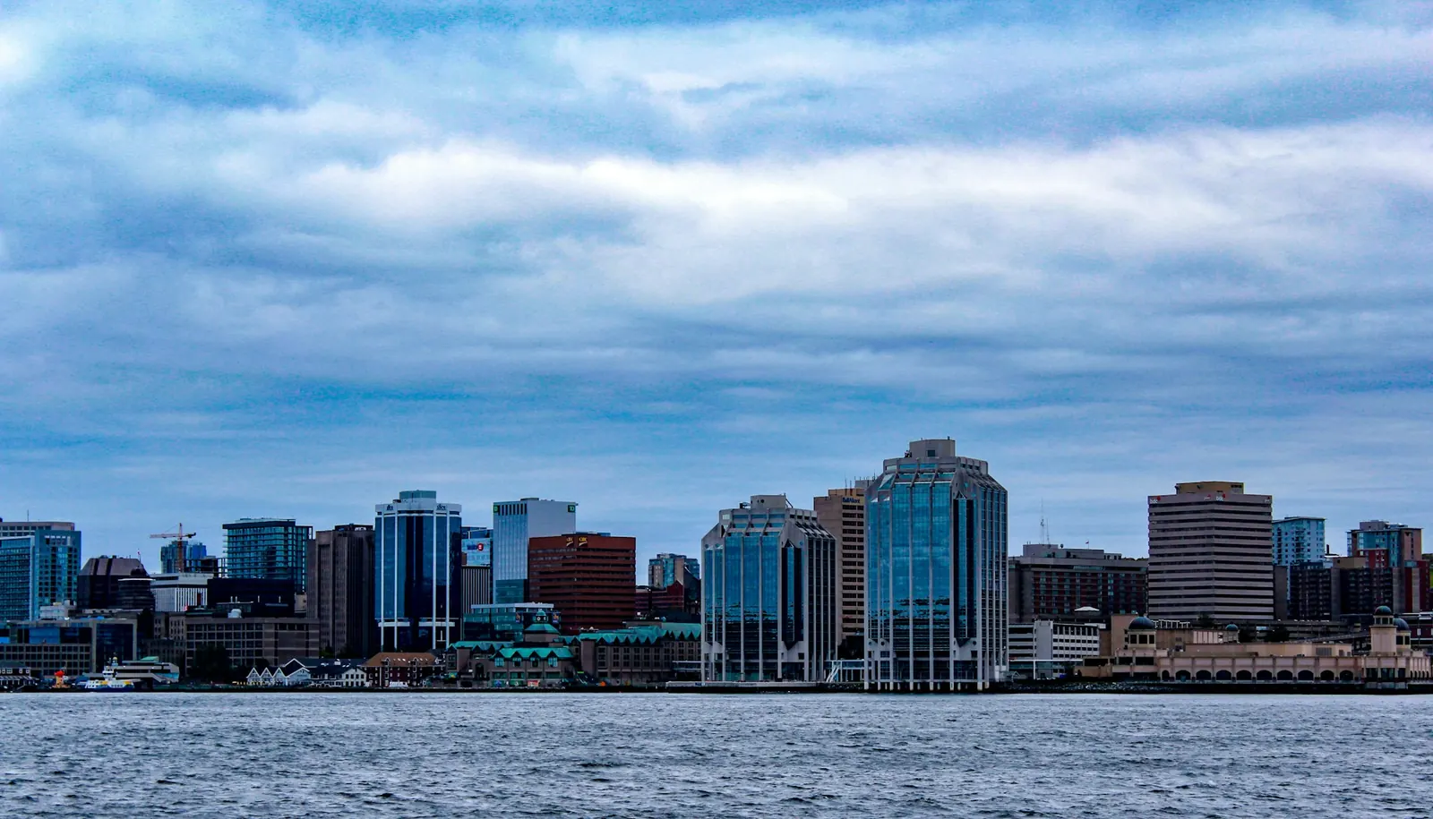 The Halifax waterfront skyline seen across the water under heavy cloud.